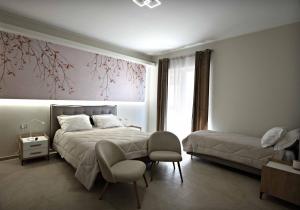 ein Schlafzimmer mit einem Bett, zwei Stühlen und einem Fenster in der Unterkunft Max's Rooms in Termoli