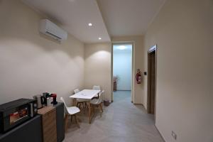 ein Zimmer mit Tisch und Stühlen und einer Küche in der Unterkunft Max's Rooms in Termoli