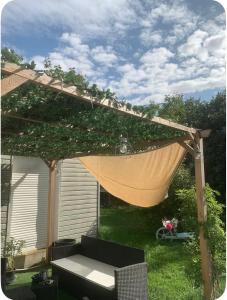 a pergola with a hammock in a yard at Les Glycines-chambre d'hôtes in Chârost
