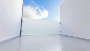 a room with a large white wall with a blue sky at Faial Inn in Horta