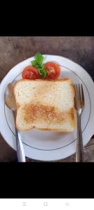 a white plate with a sandwich and a knife and fork at Rinjani inn Lombok in Tetebatu +8 photos