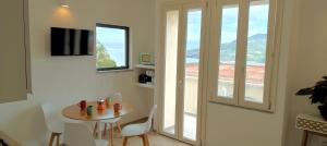 a dining room with a table and chairs and a window at Bellagio in Castelsardo