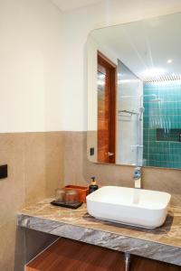 a bathroom with a white sink and a mirror at Jisa Sidemen in Sidemen +14 photos