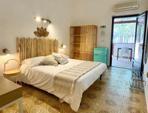 a bedroom with a bed and a door to a patio at Eraclea Minoa Village in Montallegro