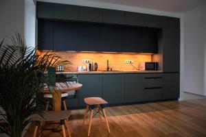 a kitchen with black cabinets and a table with chairs at Willow Nest in Balatonfůzfő