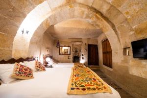 a bedroom with two beds in a stone room at Tulip Cave Suites in Göreme