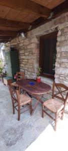 a wooden table and two chairs in front of a building at Agios Ioannis Solar Cottage - Eco-friendly, Solar Powered in Raches +34 photos