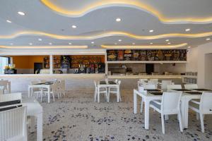 a restaurant with white tables and white chairs at SOLANA By YELKEN in Turgutreis