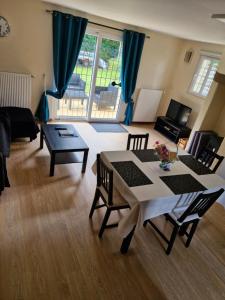 a living room with a table and chairs at Gîte au coeur du pays dinannais in Plumaudan