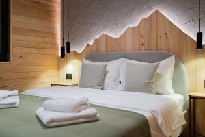 a bedroom with a bed with towels on it at Nordlys Retreat in Teşila