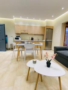 a living room with tables and chairs and a kitchen at Apartment Jorgo Kalithea in Kallithea Halkidikis