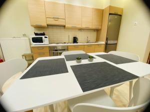 a kitchen with a white table and white chairs at Apartment Jorgo Kalithea in Kallithea Halkidikis