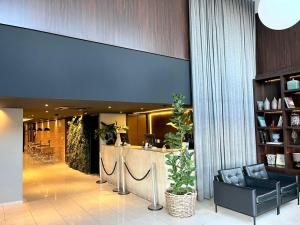 a lobby with a bar in a building with plants at Oasis Tower Hotel in Ribeirão Preto