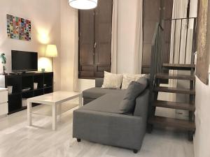 a living room with a couch and a table at Galvez Rosa Apartment in Málaga