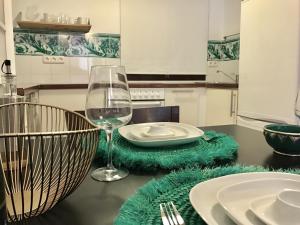 a table with a glass of wine and a green rug at Galvez Rosa Apartment in Málaga