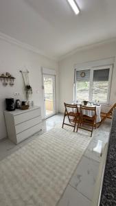a white room with a table and a kitchen at Peribacası Manzaralı Modern Daire in Ürgüp