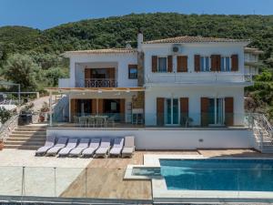 a house with a swimming pool in front of it at Villa Helia in Yénion