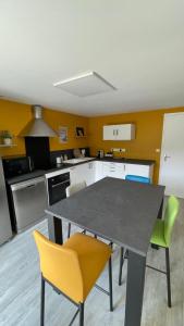 a kitchen with a table and yellow chairs at Les Cyprès in Vienne +13 photos