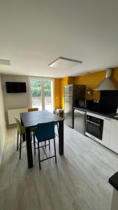 a kitchen with a table and chairs in a room at Les Cyprès in Vienne