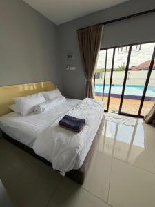 a bed in a bedroom with a view of a pool at Untung5tay in Gua Sai