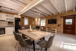 a kitchen and dining room with a wooden table and chairs at Artemis Luxury Villa in Méson Yerakaríon