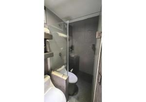 a bathroom with a glass shower with a toilet at Habitación Tulipán in Oaxaca City