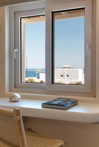 a window with a keyboard sitting on a window sill at Pnoé Lounge Suite in Mandrakia
