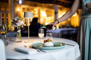 a person pouring white wine into a glass on a table at Conero Azzurro in Numana +69 photos