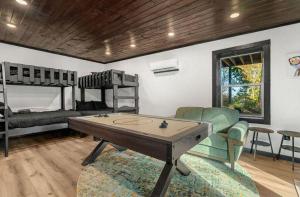 a living room with a ping pong table and bunk beds at Soakin Up The Views in Gatlinburg +26 photos