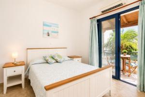 a bedroom with a bed and a balcony at Villa Driftwood in Rhodes Town