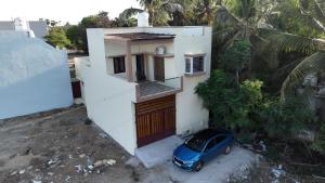 a blue car parked in front of a house at Bay Breeze Vijay Villa in Pondicherry