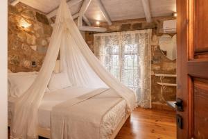 a bedroom with a bed with a mosquito net at Artemis Luxury Villa in Méson Yerakaríon +20 photos
