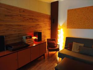 a living room with a couch and a table with a television at Zaļais namiņš in Ventspils