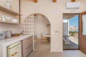 an archway in a kitchen with a view of the ocean at Pnoé Lounge Suite in Mandrakia