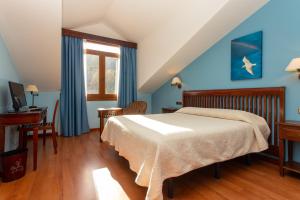 a bedroom with a bed and a desk and a window at Hotel Bufon de Arenillas in Vidiago +46 photos