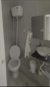 a bathroom with a white toilet and a sink at Bilbao Habitaciones in Bilbao