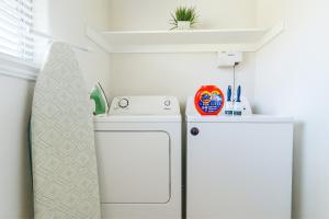 a small laundry room with a washer and a white refrigerator at 102 Cecil Cir 3BR2 House in Calera