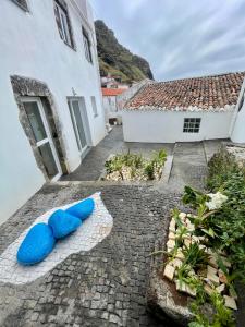 two blue pillows sitting on the ground in a courtyard at Casa do Henri in Corvo