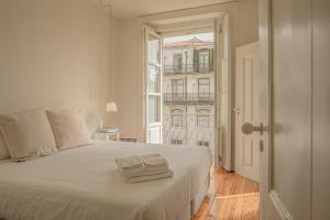 a bedroom with a white bed and a window at Antiga Casa Pessoa in Lisbon