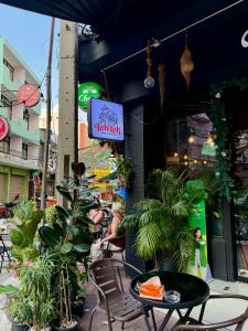 a restaurant with a table and chairs and a sign at TUKTUK Home in Samphanthawong