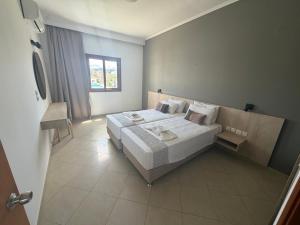 a bedroom with a large white bed and a window at Stemma Hotel in Sidari +21 photos