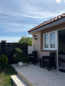 a patio with two chairs and a table and a window at Airport Apartment Masa in Mitrovići