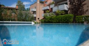a large blue swimming pool in front of a building at Ca' Rossa Lido Venezia in Mestre