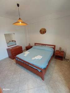 a bedroom with a bed and a dresser and a lamp at Alba Blu Sampieri in Sampieri
