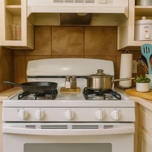 a white stove with a pan on top of it at Cozy Cottage Centrally Located WorkerFriendly in Sherman +2 photos