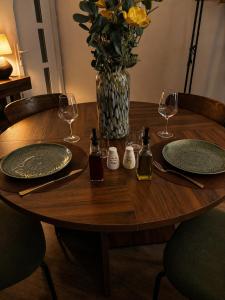 a wooden table with two plates and a vase with flowers at Studio chic et confortable in Lorgues +3 photos