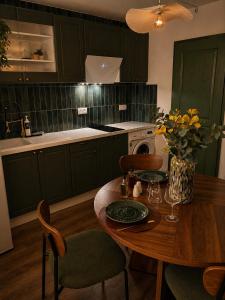 a kitchen with green cabinets and a wooden table at Studio chic et confortable in Lorgues
