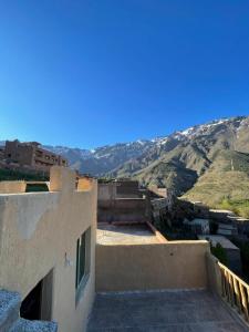a view of a building with mountains in the background at Gite Dar Tanzoughte in Imlil