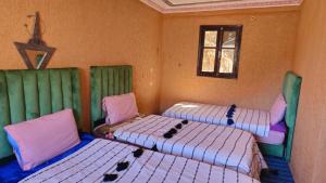 a room with two beds in a room at Gite Dar Tanzoughte in Imlil