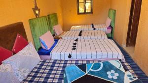 two beds are in a room with at Gite Dar Tanzoughte in Imlil +34 photos
